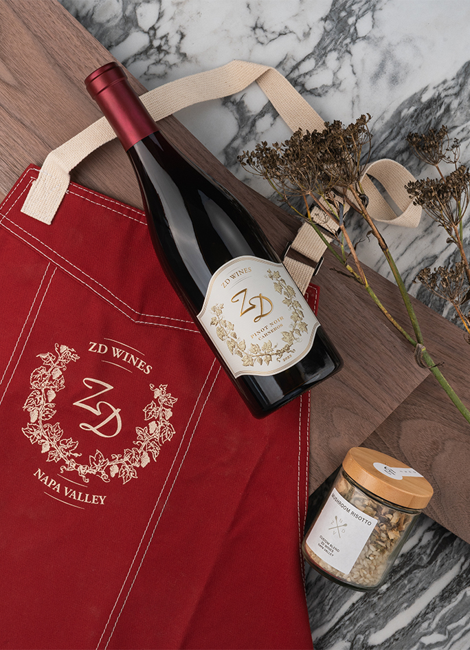 A ZD Pinot Noir placed on a ZD apron, along with a ZD risotto jar