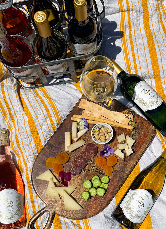 ZD wines on a picnic cloth with a cheese plate