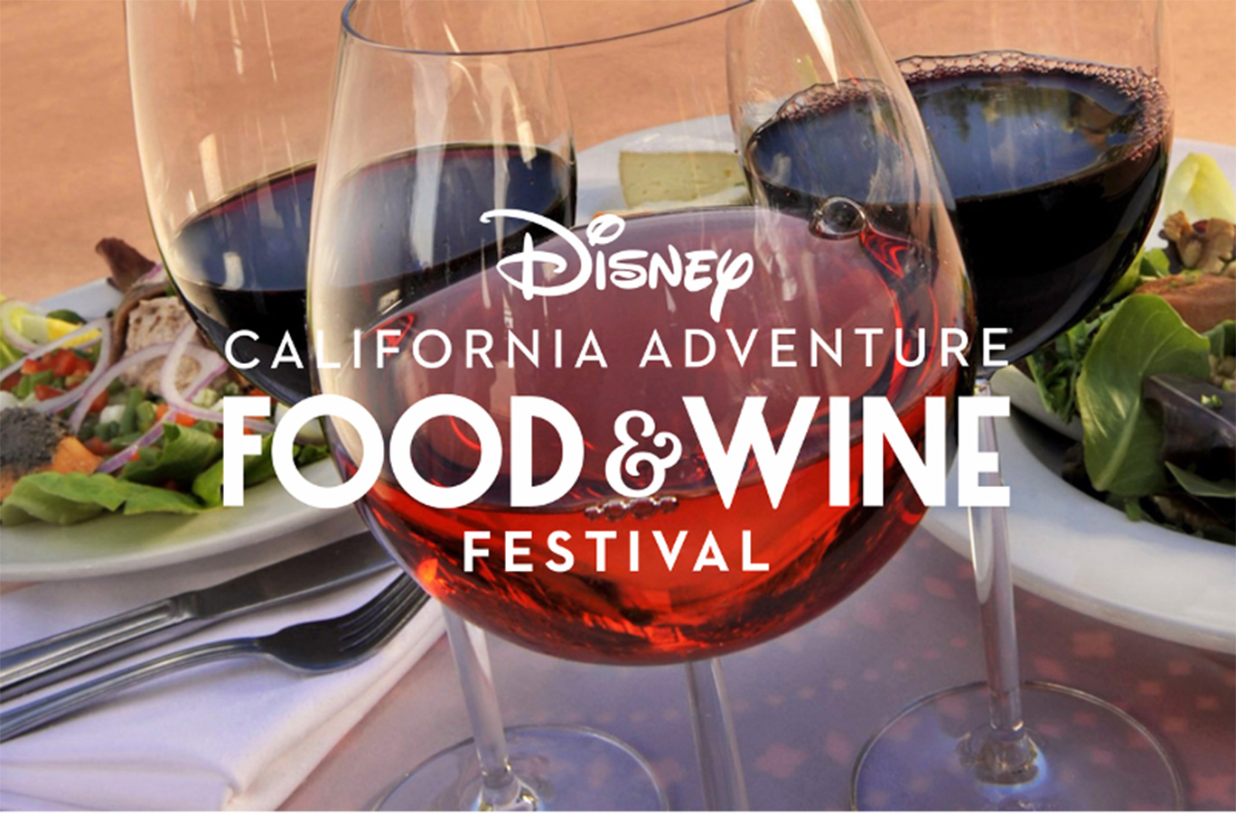 A table with 3 wine glasses and two plates of food.